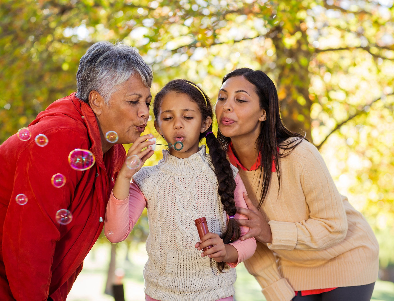 Retired Grandmother Blowing Bubbles with Daughter and Grandchild