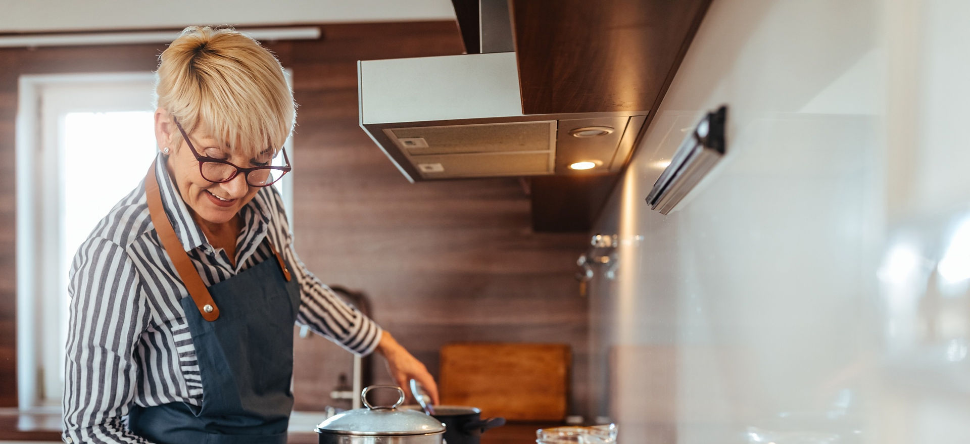 Elderly woman cooking for family in retirement